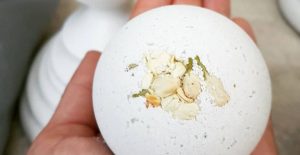 Ashbury Bloom Refreshing escape Bath bomb being held in the hand.