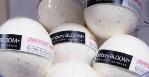 Handmade bath bombs wrapped in Biolefin shrink film with visible botanicals for eco-friendly wholesale packaging.