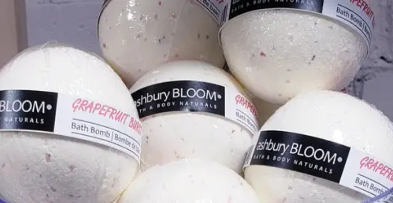 Handmade bath bombs wrapped in Biolefin shrink film with visible botanicals for eco-friendly wholesale packaging.