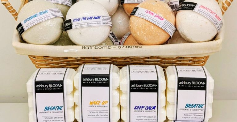 Display of ashbury BLOOM• shower steamers beneath a basket of handmade bath bombs